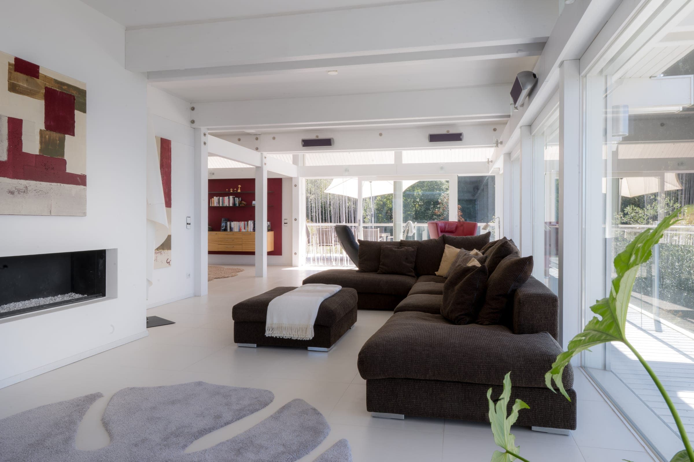 Wohnraum mit Kamin, Sofa und Durchblick zur Terrasse