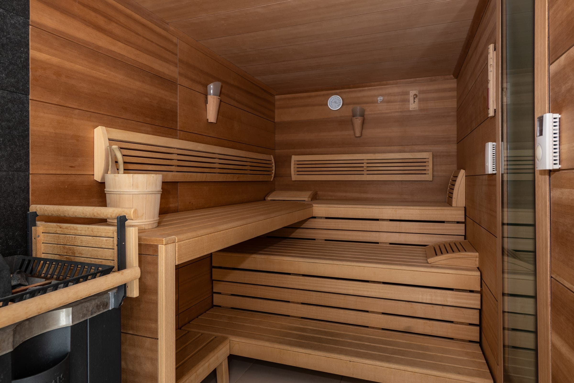 Sauna aus hellem Holz mit zwei Bankreihen