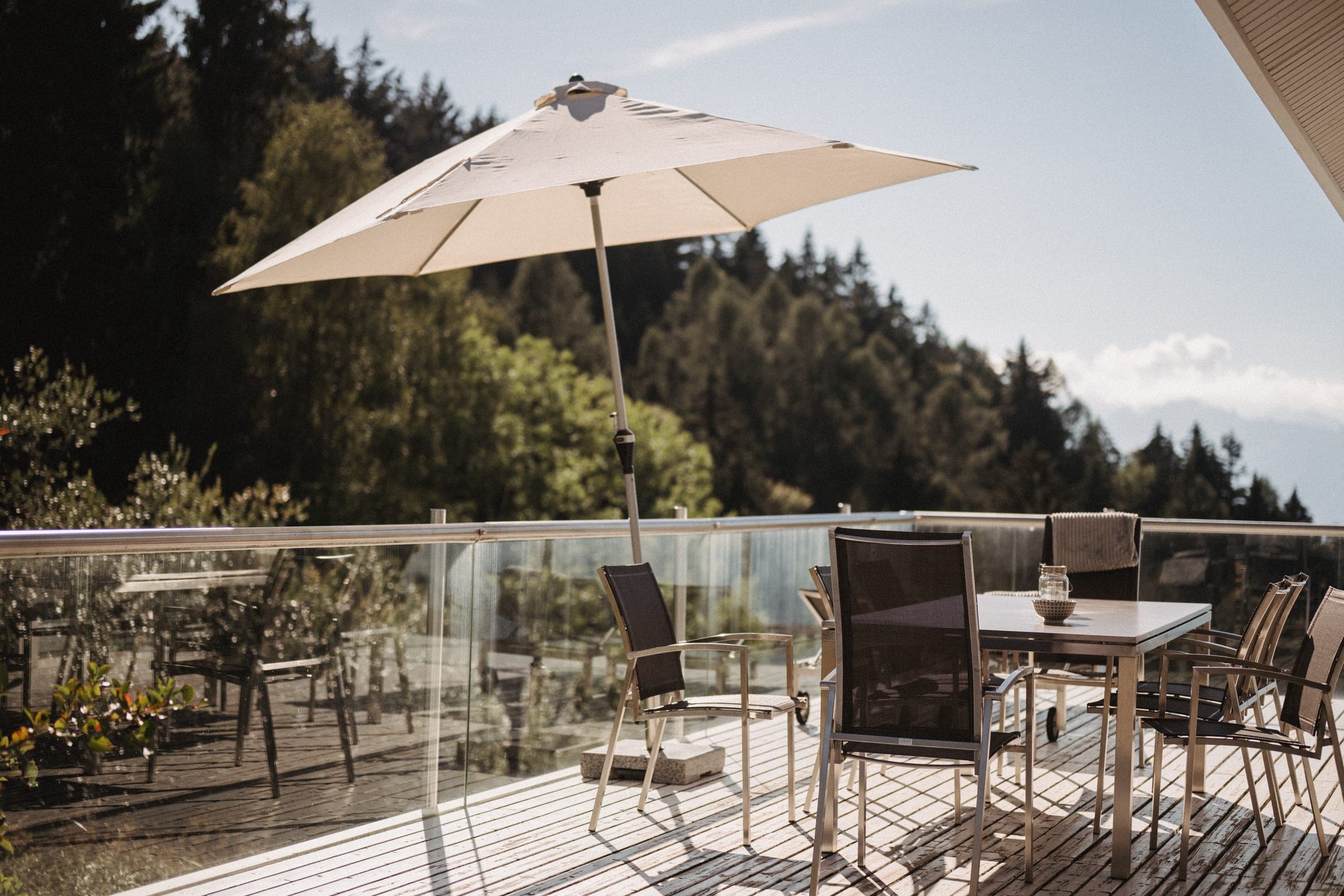 Terrasse mit Sonnenschirm, Tisch und Stühlen
