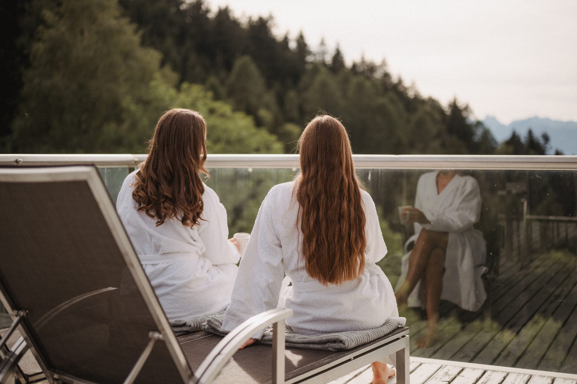 Two guests on the terrace with a view over the forest