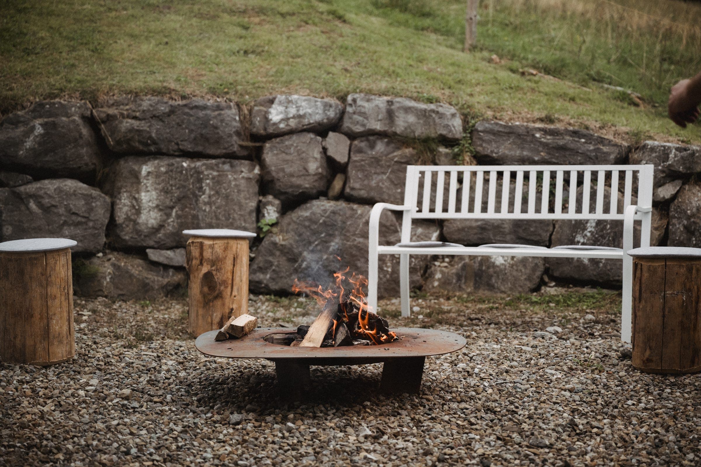 Fire bowl and bench in front of the stone wall