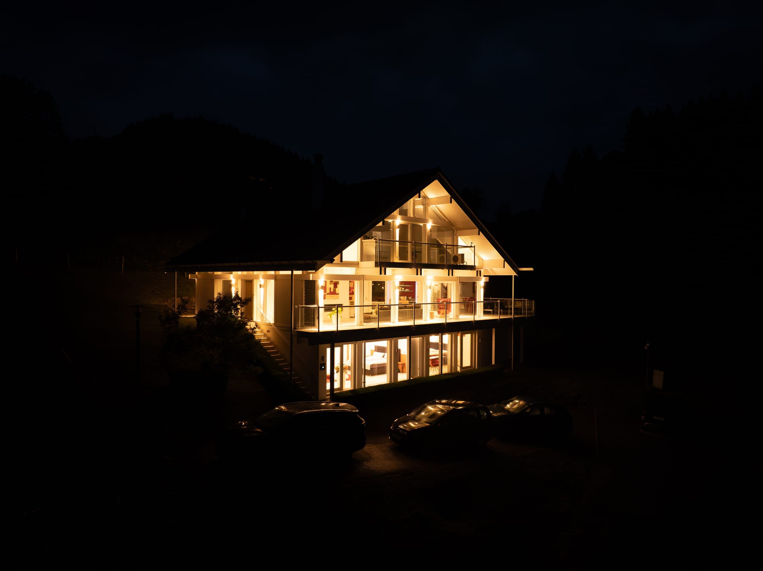 Das Haus bei Nacht von oben, alle Fenster erleuchtet